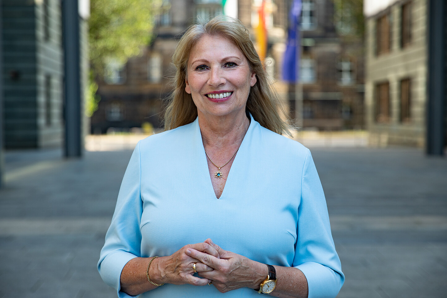 Porträtfoto von Staatsministerin Petra Köpping. Sie trägt ein hellblaues Kleid. Das Bild wirkt hell und freundlich. Sie lächelt freundlich in die Kamera.